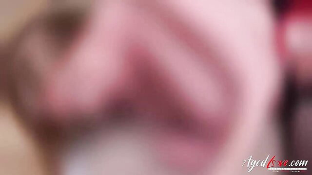 Blurry closeup of mature woman's large pinkish breasts and cleavage