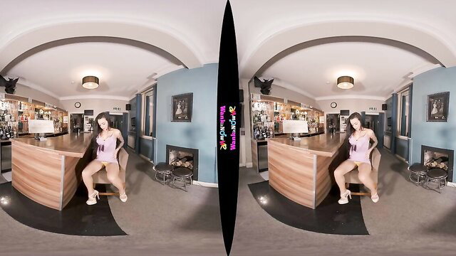 Asian babe in pink dress sits on bar stool in VR 360 porn