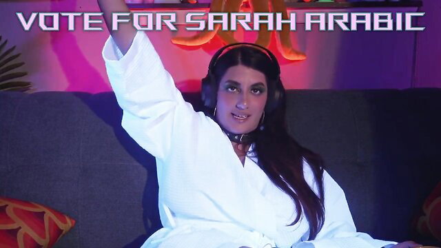 Sarah Arabic in white robe with headphones, vote for 2023 FleshBot Awards