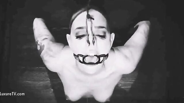 Extreme BDSM bound woman gagged in religious fetish pose