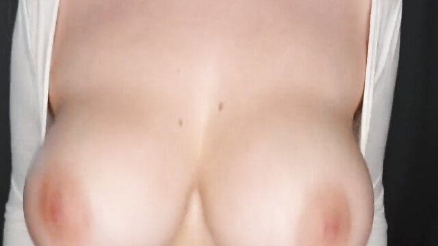 MILF with massive tits showing pale cleavage in white top