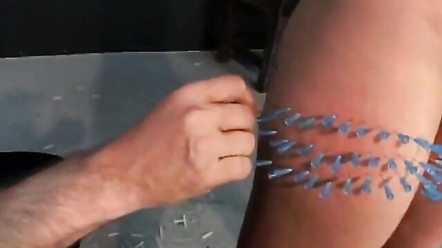 Woman's thigh pierced with blue needles in extreme pain pleasure fetish