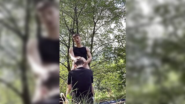 Outdoor gay amateur blowjob: slim twink kneels sucking dude in woods