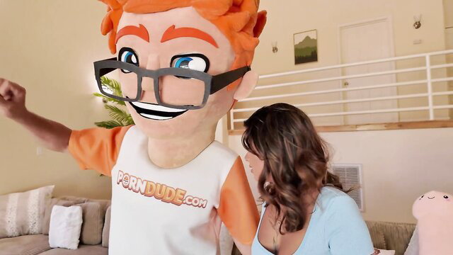 Isabella Jules with Porn Dude mascot in teasing living room pose