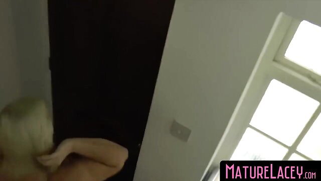 Blonde UK mature Lacey Starr topless teasing by window