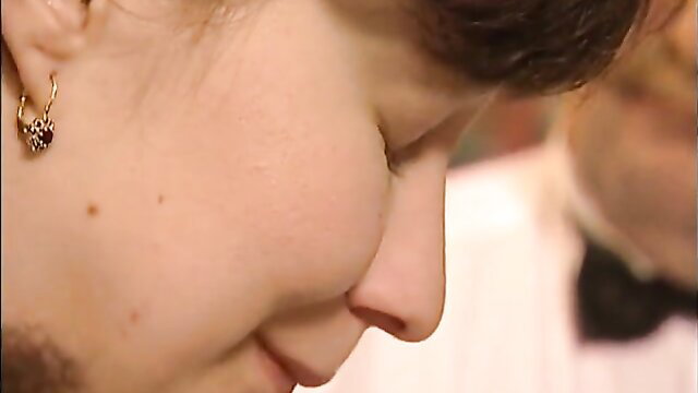 Closeup of smiling woman's face and earrings in fetish group sex scene