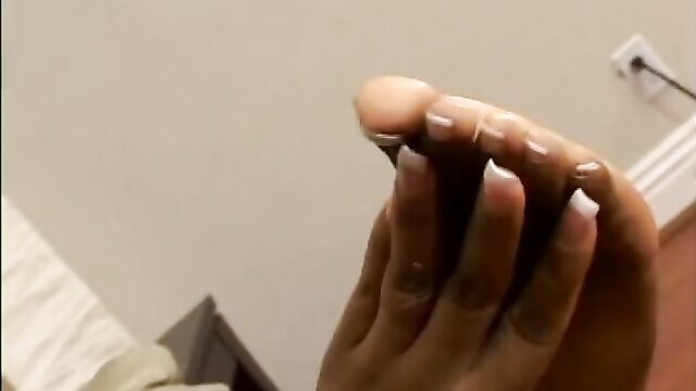 Closeup of ebony woman's sexy feet and long white nails in hot tease