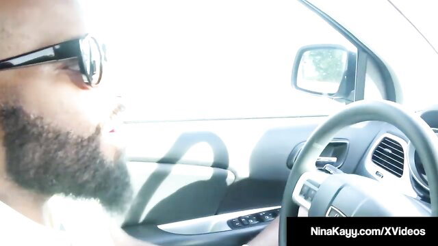 Nina Kayy in car with man wearing sunglasses bearded