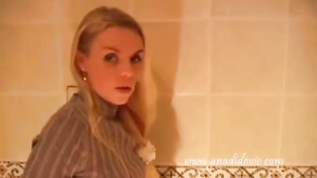 Blonde scat girl in turtleneck stares seductively in bathroom poop scene