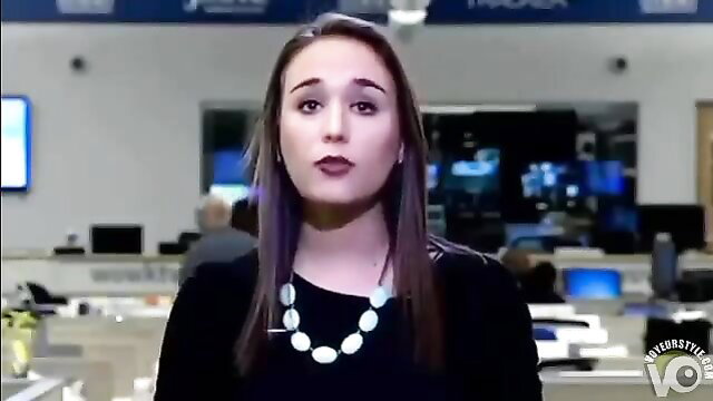 Brunette office employee in black top and pearl necklace on trading floor