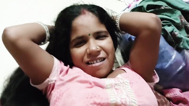 Hot Indian bhabhi in pink top smiling seductively with arms up, laundry tease