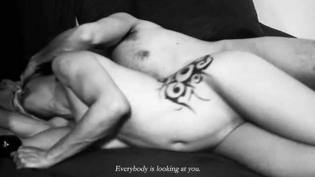 Hot Asian couple nude embrace, tribal tattoo on hip, intense eye contact