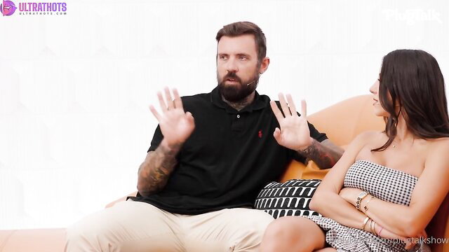 Lena The Plug interviews Sav Shawz on PlugTalk, busty brunette in dress