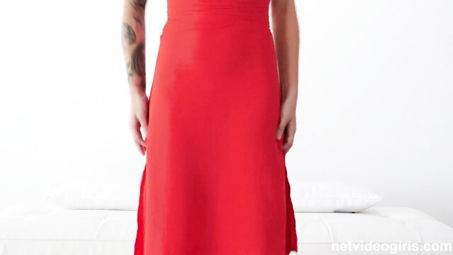 Brunette beauty with tattoos in tight red dress showing curves