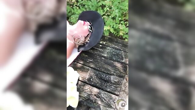 Busty mom lying back on wood deck, sunglasses and hat, outdoor tease