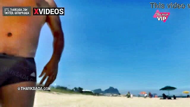 Hot muscular Brazilian guy in speedo on beach, abs exposed