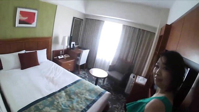 Asian mature MILF in 40s smiling in hotel room, green dress POV