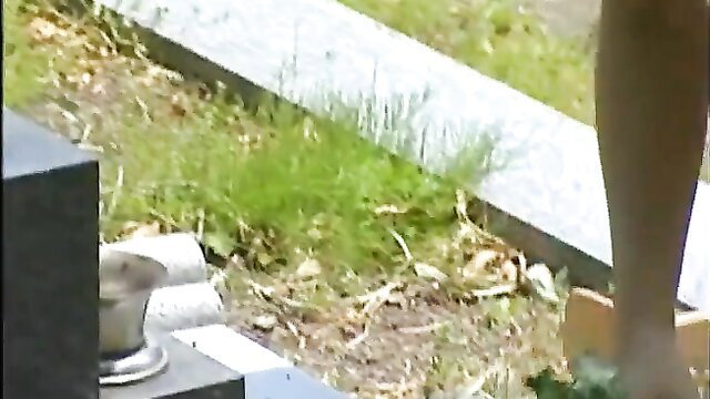Closeup of woman's bare legs and ass outdoors near gravestone