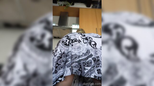 Closeup of woman's curvy ass in ornate black white dress bending over