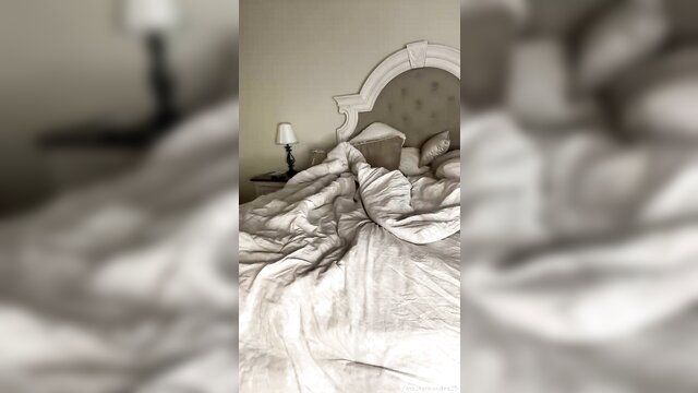 M Fernandes solo in tangled white sheets on bed