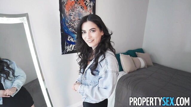 Hot brunette in denim jacket and mini skirt poses sexy in bedroom