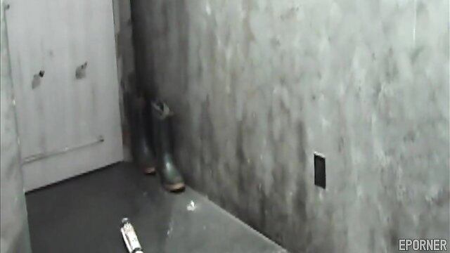 Kinky femdom submissive in boots and wet floor BDSM dungeon scene