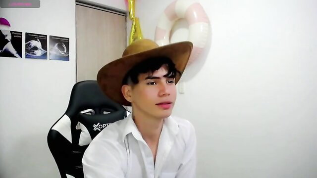 Fresh Colombian twink in cowboy hat and white shirt on gaming chair