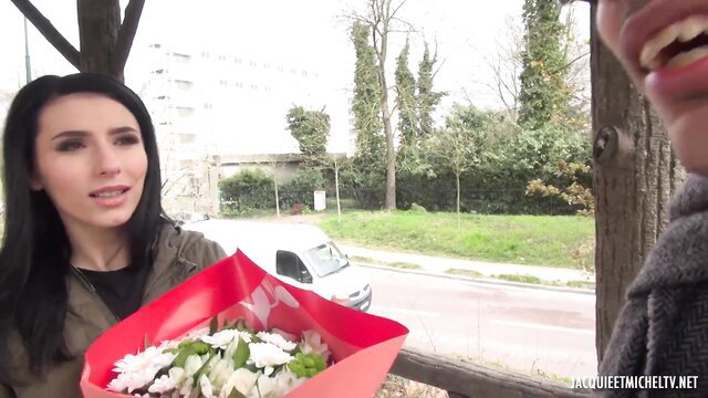 Nelly Kent receives flowers from smiling fan outdoors, teasing smile