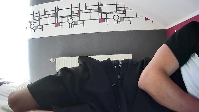 Gay amateur dude in black shorts lying on bed, muscular legs exposed