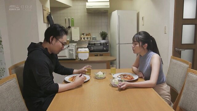 Asian married couple eating pasta at kitchen table in JAV