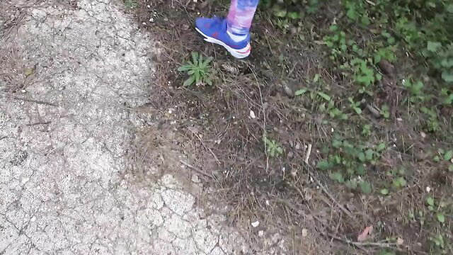 Souzan Halabi's legs in blue Nike sneakers and patterned leggings outdoors