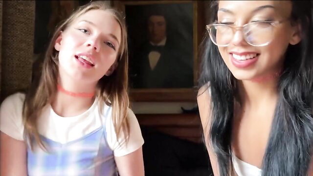 Two hot girls in glasses smiling playfully in lesbian fetish tease