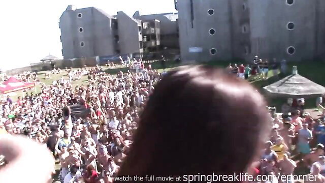 Crowded spring break beach party with bikini girls and shirtless guys