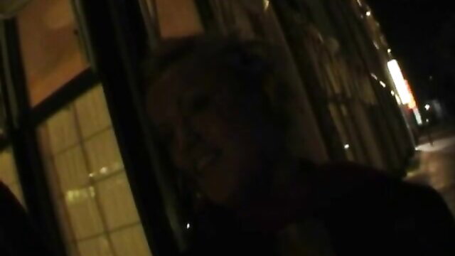 Blonde cougar reflected in window at night, teasing holiday vibe