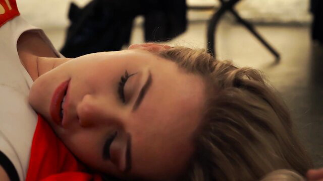 Blonde bombshell lying asleep in red lingerie, seductive pose