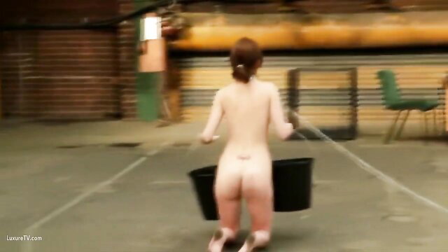 Nude redhead slave girl with bucket, big ass bent over in BDSM training