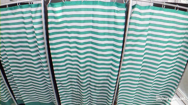 Angel Wicky behind green striped shower curtains in hot busty tease