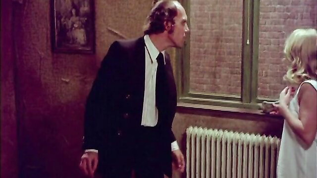 Blonde babe in white dress chats with suited man in Justine And Juliette 1975