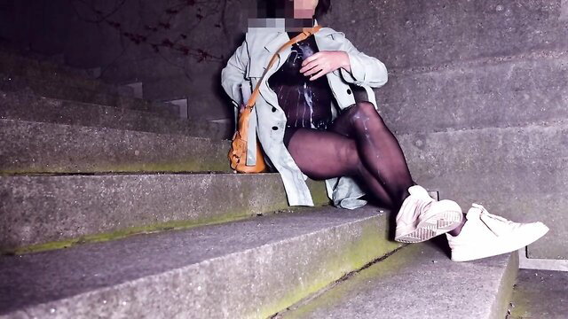 Crossdresser in sheer body and stockings sits legs spread on stairs