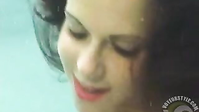 Underwater beauty with wet hair smiling seductively in pool