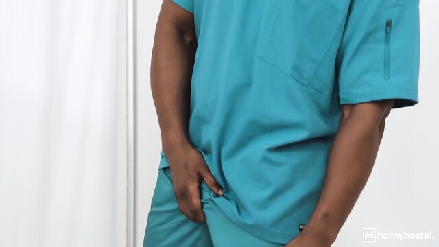 Black male doctor in scrubs grabs crotch in sexy nurse pose