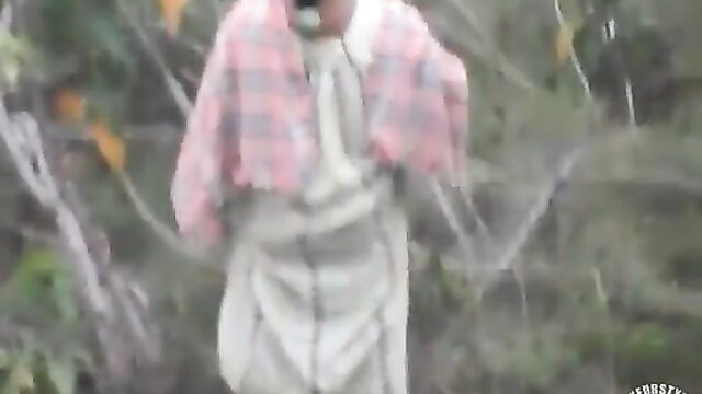 Indian woman in pink shawl and white dress squatting in grass voyeur video