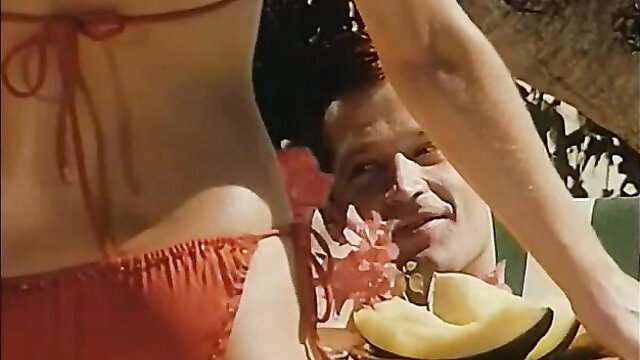 Retro blonde in red bikini teases tanned guy in hat, Ibiza beach vibes