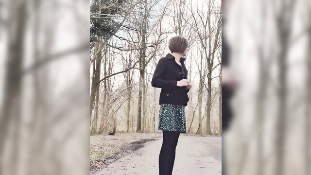 Annemieke in black jacket, mini skirt, stockings public park pose