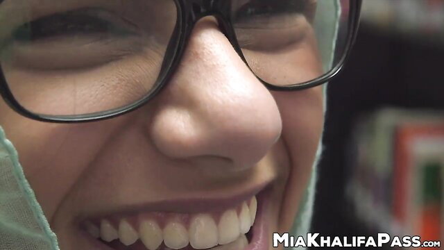 Mia Khalifa smiling in glasses and hijab in library tease