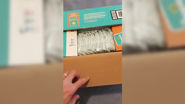 Woman opening box of Pampers baby-dry size 7 diapers, adult diaper fetish