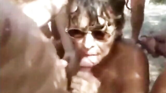 Mature woman in Cap d'Agde sucks multiple strangers outdoors