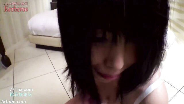 Shy Japanese emo girl with bangs closeup smile in hotel room