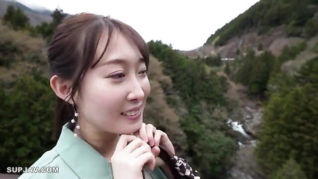 Asian beauty in green hanbok smiling in scenic mountains, softcore JAV tease