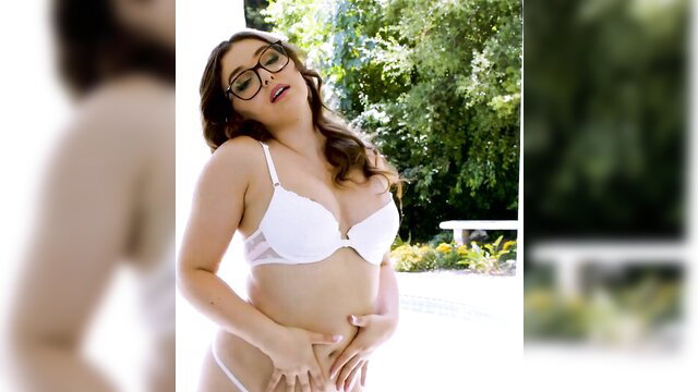 Curvy brunette in glasses and white lingerie poses seductively outdoors